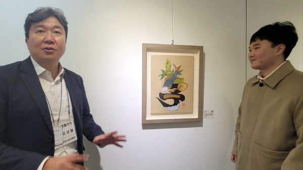 이상현 작가와 함께 작품에 대해 설명하는 (주)에이블룸아트의 김상철 대표.